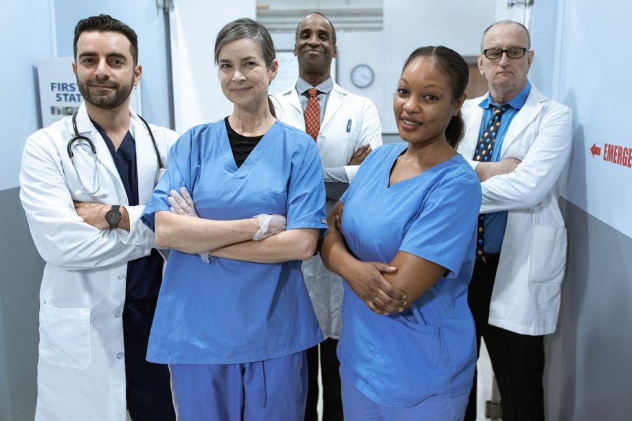 healthcare workers standing in a group in a hospital hallway.