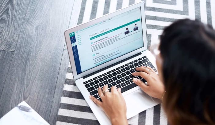 View from behind woman using laptop for training